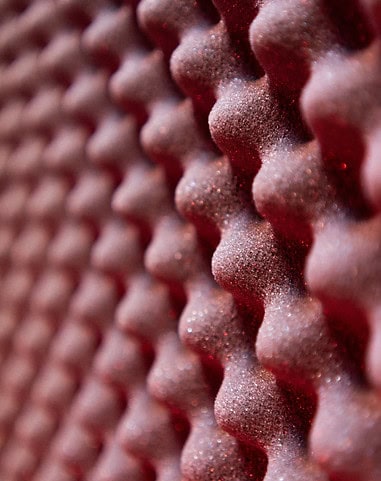 Close-up of red, textured acoustic wall panels for soundproofing and interior decor in South Africa.