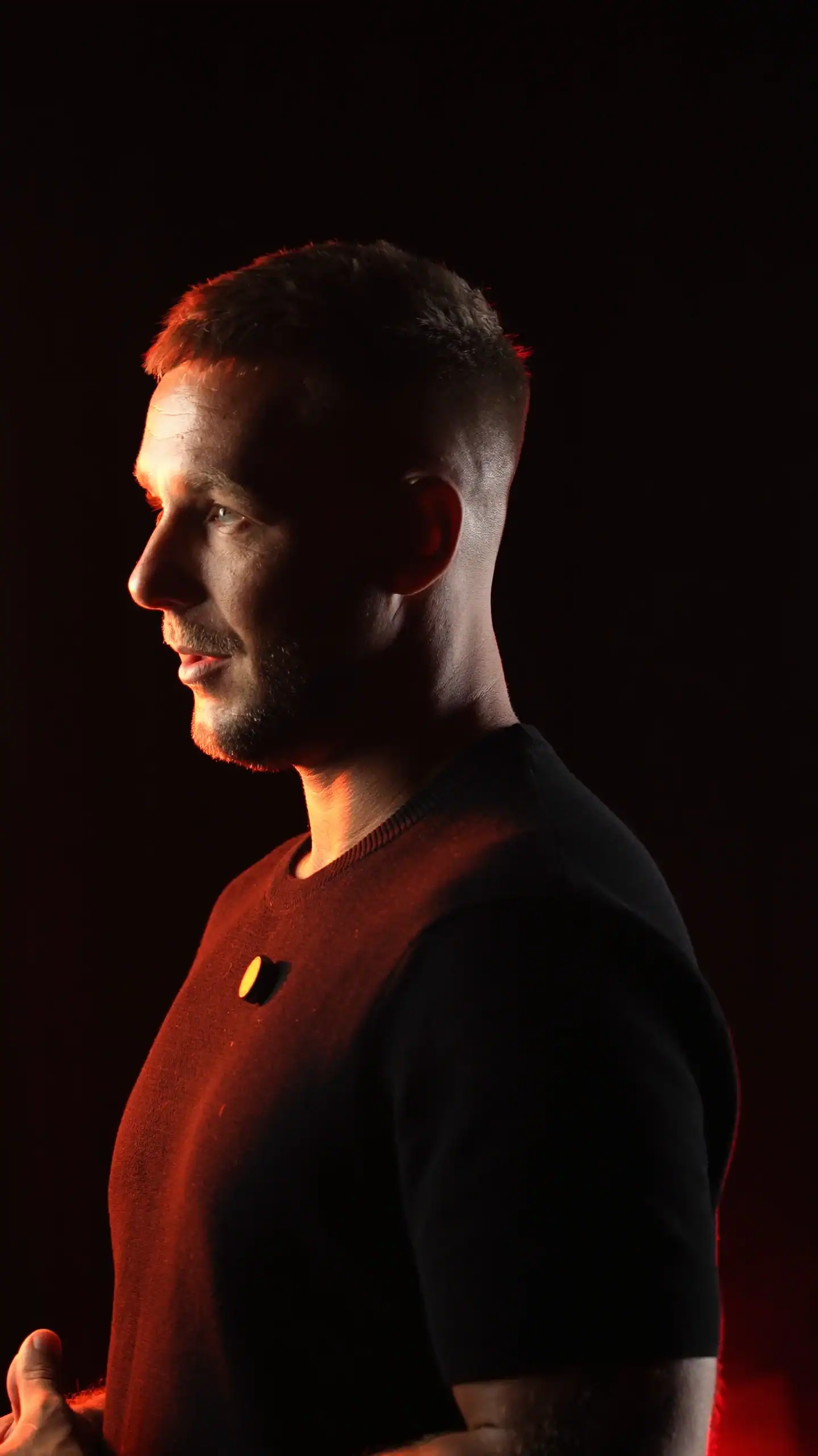 Portrait of a young man in dramatic lighting with a dark background, highlighting modern portrait photography by Villo Studio.