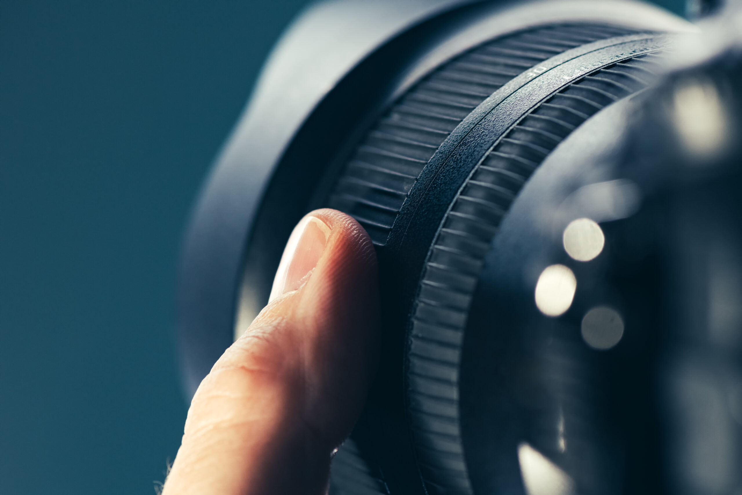 Photographer using zoom lens on DSLR camera, close up of finger rotating the ring on photographic equipment part